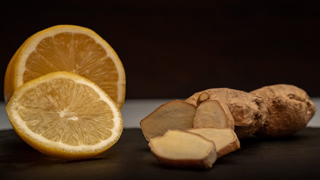 Close-up of fresh ginger root and lemon slices, highlighting their vibrant natural textures and health benefits.